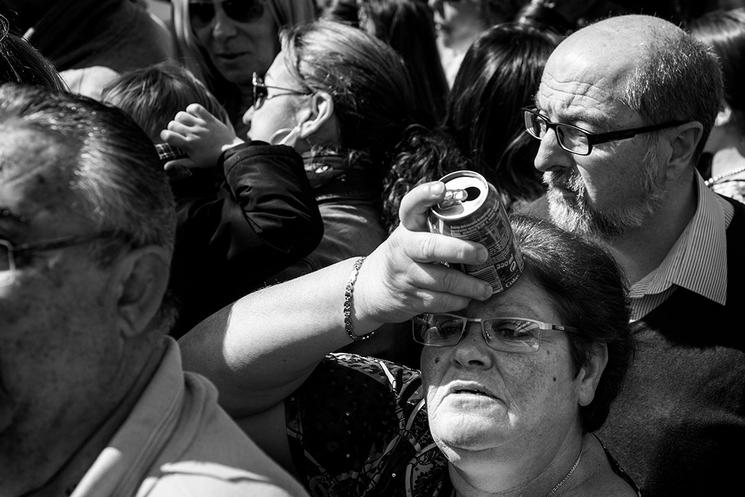 People drinking and cooling off in a crowd.